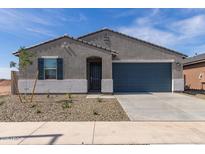 Charming single-story home with a gray stucco exterior, gray roof and a 2-car garage, and low-maintenance landscaping at 16004 W Honeysuckle Dr, Surprise, AZ 85387