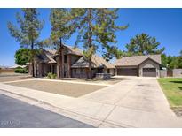 Charming single-Gathering home features a neutral color palette, spacious driveway, and mature trees in the front yard at 1750 E Mallory St, Mesa, AZ 85203