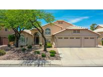 Charming home featuring a three car garage, desert landscaping, and a beautiful shade tree at 19506 N 73Rd Ave, Glendale, AZ 85308