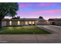 Charming single-story home with a manicured lawn and arched entryway at twilight at 2025 E Magdalena Dr, Tempe, AZ 85283