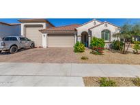 Charming single-story home boasts a red-tiled roof, stucco exterior, and a well-maintained front yard with colorful landscaping at 25601 N 140Th Ln, Surprise, AZ 85387