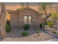 Charming home featuring a stone base, neutral stucco, desert landscaping, and a tile roof at 2567 E San Isido Trl, Casa Grande, AZ 85194