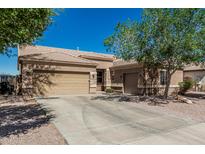 Charming single-story home featuring a three-car garage, desert landscaping, and a tile roof at 26264 N 74Th Ln, Peoria, AZ 85383