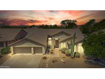 Inviting front exterior featuring a well-manicured yard and a convenient three-car garage with a sunset at 29816 N 51St Pl, Cave Creek, AZ 85331