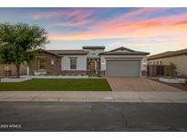 Stunning single-story home with stone accents, a paver driveway, and a lush front lawn at 3038 E Longhorn Dr, Gilbert, AZ 85297