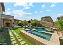 Inviting backyard featuring a sparkling pool, spa, and outdoor kitchen area perfect for entertaining at 3817 E Patrick Ln, Phoenix, AZ 85050