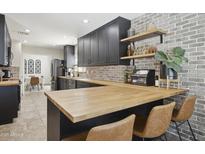 Charming kitchen features butcher block counters, brick accents, stainless appliances, and custom cabinets at 4137 W Cielo Grande --, Glendale, AZ 85310