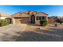 Charming single-story home featuring desert landscaping, a two-car garage, and a tiled roof at 42067 W Anne Ln, Maricopa, AZ 85138