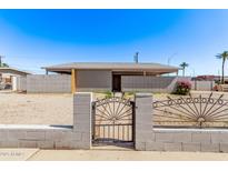 Modest single-story home featuring a gravel front yard and gated block fence at 5902 W Orange Dr, Glendale, AZ 85301