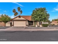 Charming single-story home with a well-maintained lawn, mature trees, and a two-car garage at 1001 N Nielson St, Gilbert, AZ 85234