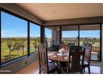 Bright dining area featuring a table set for four with panoramic views of the lush green golf course through expansive windows at 1040 E Osborn Rd # 501, Phoenix, AZ 85014
