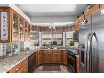 Inviting kitchen featuring granite countertops, stainless steel appliances, and a charming bay window at 11206 W Sieno Pl, Avondale, AZ 85392