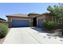Charming single-story home with a desert-landscaped front yard, blue garage doors, and stone accents at 1241 E Palo Verde Dr, Casa Grande, AZ 85122