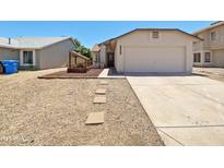 Charming single-story home featuring a two-car garage, desert landscaping, and a quaint garden feature at 1739 E Carter Rd, Phoenix, AZ 85042