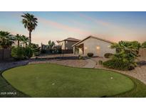 Inviting backyard featuring a putting green, desert landscaping, and a trampoline, perfect for outdoor fun at 19576 N Portarosa Ct, Maricopa, AZ 85138