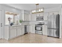 Bright kitchen featuring stainless appliances, white cabinets, and stylish lighting at 2313 N 87Th Way, Scottsdale, AZ 85257