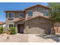 Two-story home featuring a tile roof, desert landscaping, and a two-car garage at 43670 W Mcclelland Ct, Maricopa, AZ 85138