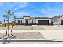 Inviting single-story home featuring desert landscaping, a two-car garage, and a welcoming entrance at 15349 W Cottontail Ln, Surprise, AZ 85387