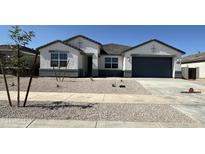 Charming single-Gathering home featuring a gray garage door, modern stucco, and low-maintenance desert landscaping at 15429 W Cottontail Ln, Surprise, AZ 85387
