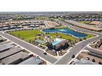 An aerial view showing a community pool, playground, and pond in a new neighborhood at 19195 N Los Gabrieles Way, Maricopa, AZ 85138
