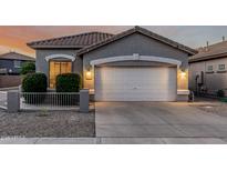 Charming single-story home showcasing a well-manicured front yard and a two-car garage at 20858 E Sonoqui Dr, Queen Creek, AZ 85142