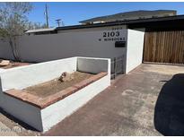 The exterior of the apartment features white stucco and a small planter at 2103 W Missouri Ave, Phoenix, AZ 85015