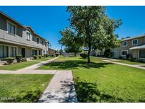 Exterior shows a community with green grass, trees, and light grey buildings on a clear, sunny day at 2645 W Elm St, Phoenix, AZ 85017