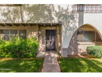 Inviting condo front entrance with lush landscaping and secure black wrought iron door at 3821 N 28Th St, Phoenix, AZ 85016