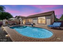 Inviting backyard pool area with brick patio, outdoor fireplace, and comfortable seating, perfect for relaxation and entertaining at 4821 E Kirkland Rd, Phoenix, AZ 85054