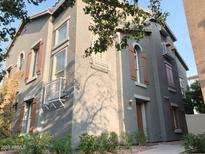 Charming two-story home with a stucco exterior, brown shutters, small balconies, and desert landscaping at 5720 S 21St Ter, Phoenix, AZ 85040