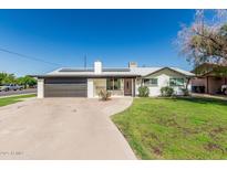 Charming single-story home with a brick facade, well-manicured lawn, and a two-car garage at 591 N Cheri Lynn Dr, Chandler, AZ 85225