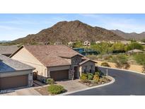Charming desert home with a tile roof, beautiful stone accents, desert landscaping, and mountain views at 6948 E Quill St, Mesa, AZ 85207