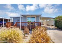 Charming single-story home with a covered porch, lush landscaping, and a convenient carport for parking at 747 E Germann Rd # 15, San Tan Valley, AZ 85140