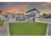 Expansive backyard featuring lush artificial turf, a raised deck, and a two-story home addition at 8436 N 13Th N Pl, Phoenix, AZ 85020
