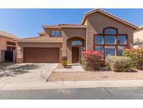 Charming two-story home featuring a well-manicured front yard, a two car garage and a classic tiled roof at 8928 E Crescent Ave, Mesa, AZ 85208