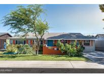 Charming single-story home with a well-maintained front yard and mature tree at 1027 E El Camino Dr, Phoenix, AZ 85020