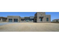 Contemporary home showcasing a blend of stucco and stone, complemented by a clean, modern driveway at 13290 E La Junta Rd, Scottsdale, AZ 85255