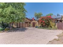 Charming home featuring unique architecture, mature trees, desert landscaping, and a textured concrete driveway at 1702 W Monterosa W St, Phoenix, AZ 85015