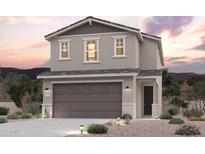 Inviting two-story home featuring a neutral color palette, a two car garage, and desert landscaping at 17373 W Jessie Ln, Surprise, AZ 85387