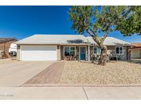 Charming single-story home featuring a well-maintained lawn, a blue front door, and a two car garage at 18233 N 55Th Dr, Glendale, AZ 85308