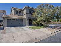 Two-story home featuring a two-car garage, a well-manicured lawn, and mature landscaping at 18811 E Pelican Ct, Queen Creek, AZ 85142