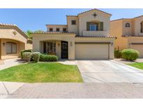 Charming two-story home with a well-maintained lawn and a two-car garage, featuring an arched entryway at 2043 W Periwinkle Way, Chandler, AZ 85248