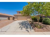 Charming two-story home featuring a two-car garage, driveway, and well-maintained landscaping with mature tree at 22196 W Tonto St, Buckeye, AZ 85326