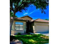 Charming single-story home boasts a tile roof, two-car garage and well-maintained front yard at 23756 S Vacation Way, Sun Lakes, AZ 85248