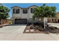 Two-story home with a gray garage door, landscaping, and a concrete driveway at 905 S Canal Dr # 17, Chandler, AZ 85225