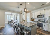 Spacious kitchen with center island, bar stool seating, and an adjacent dining area at 9752 E Torino Ave, Mesa, AZ 85212