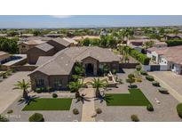 Stunning home featuring desert landscaping, palm trees and a stone facade at 10033 W Jj Ranch Rd, Peoria, AZ 85383