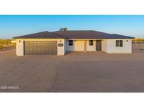Charming single-story home featuring a gray garage door and a well-maintained desert landscape at 16627 N Slate Ln, Maricopa, AZ 85139
