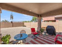 Covered patio with seating area, a grill, and a spacious gravel backyard with mountain views at 1819 W Deer Creek Rd, Phoenix, AZ 85045