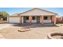 Charming single-story home featuring a covered porch with brick columns and a well-maintained front yard at 2227 N 57Th Dr, Phoenix, AZ 85035